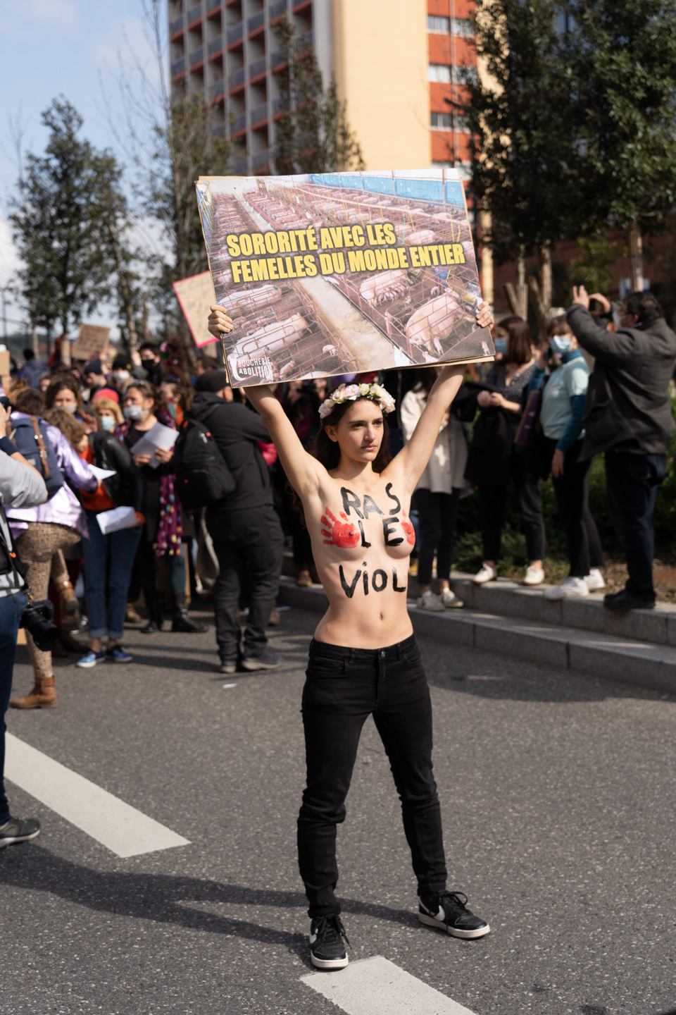 Seins nus, une militante de la cause animale montre une pancarte sur laquelle on peut lire  "Sororité avec les femelles du monde entier" lors de la manifestation pour la journée sur les droits des femmes. Toulouse, 8 mars 2021.