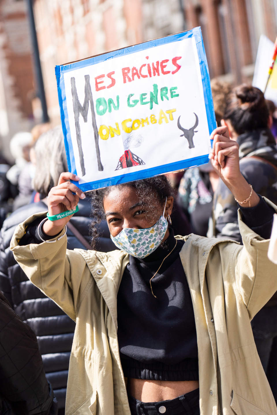 Une manifestante noire montre une pancarte sur laquelle on peut lire "Mes racines, mon genre, mon combat" lors de la manifestation pour la journée sur les droits des femmes. Toulouse, 8 mars 2021.