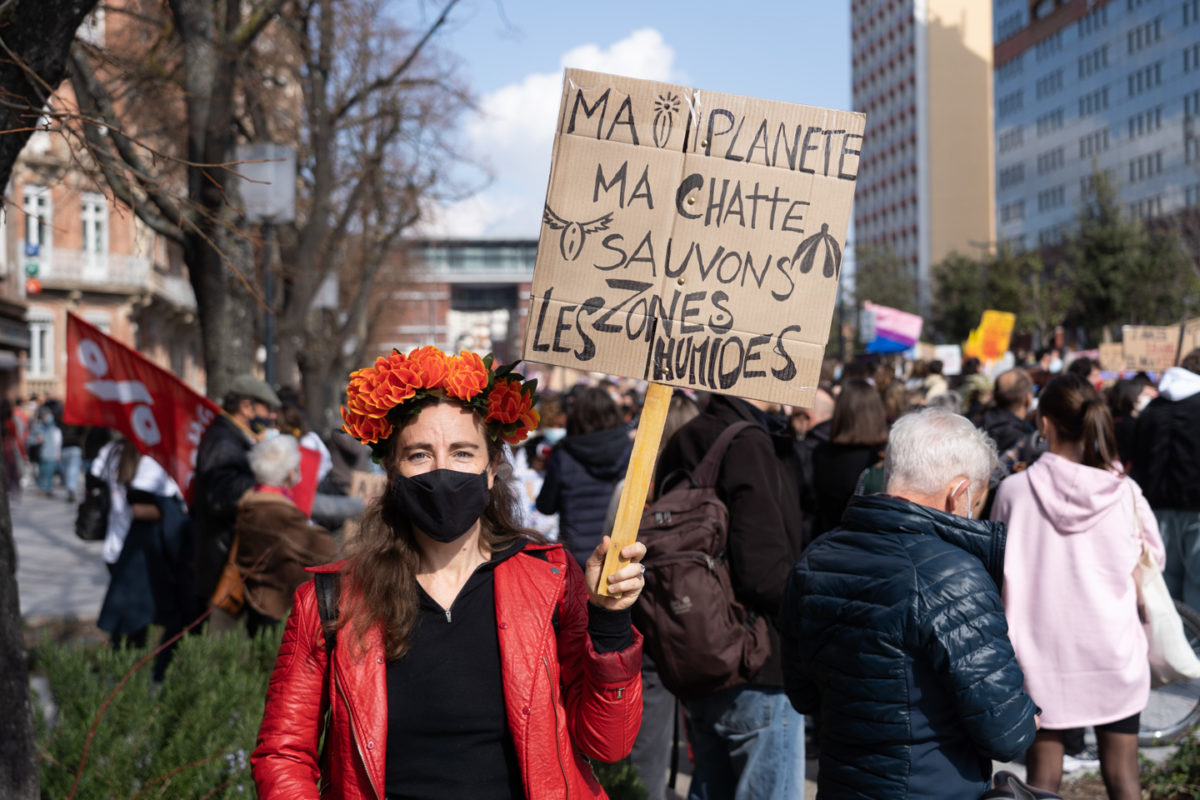 Une manifestante montre une pancarte sur laquelle on peut lire "Ma planète, ma chatte, sauvons les zones humides" lors de la manifestation pour la journée sur les droits des femmes. Toulouse, 8 mars 2021.