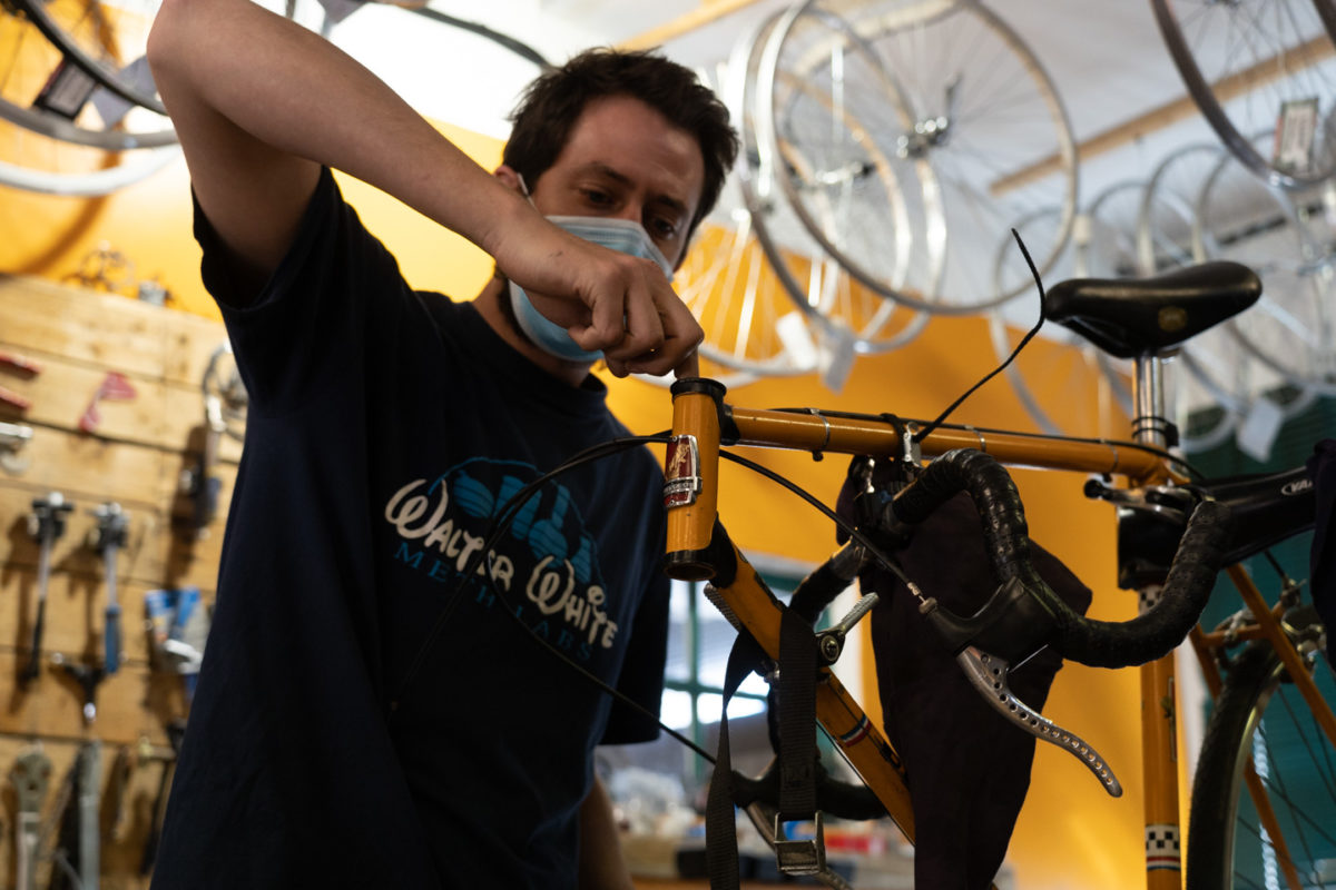 Un employé de la boutique de réparation de vélo Mécanicycle graisse le tube de direction d'un vélo. Toulouse, le 23 avril 2021.