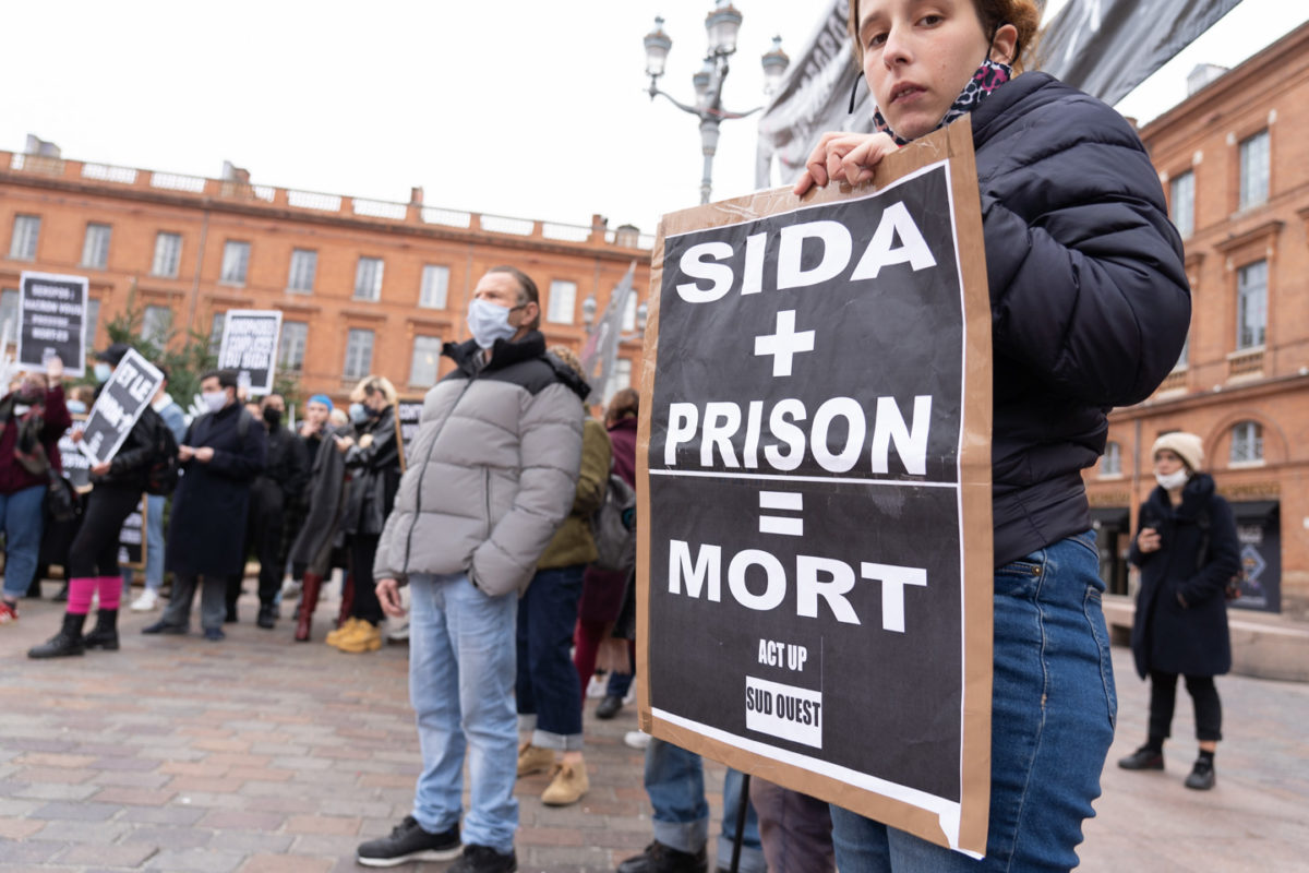 Une militante d'ActUp tient un panneau sur lequel est écrit "SIDA + prison=mort"  à l'occasion du rassemblement organisé par ActUp Sud-Ouest pour la journée mondiale contre le VIH/SIDA. Toulouse, le 1er décembre 2020.