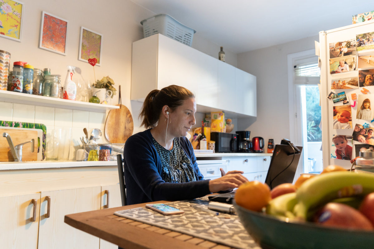 Une formatrice en langue anglaise donnant un cours à distance pendant le confinement depuis la cuisine de son appartement. Sur le réfrigérateur, des photos de famille. Toulouse, 25 novembre 2020.