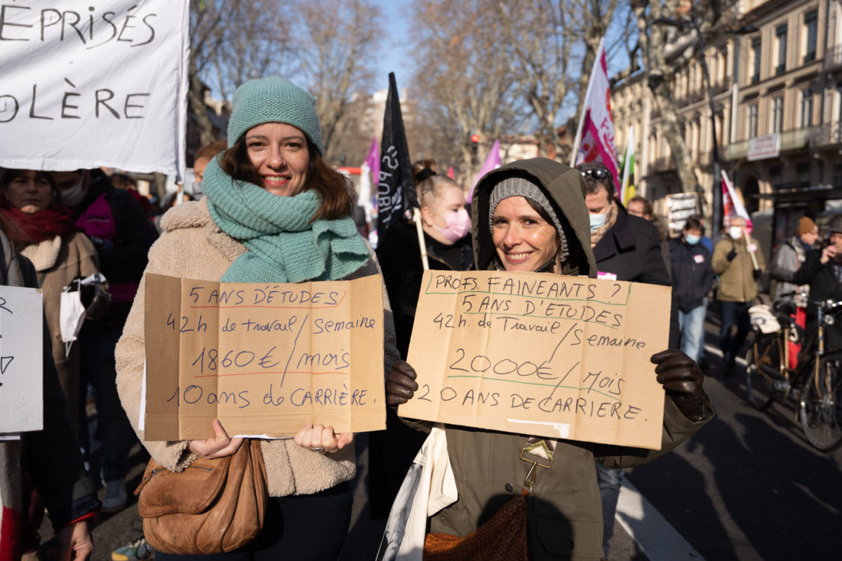 Des professeures brandissent des pancartes exposant la réalité de leurs rémunérations lors de la manifestation interprofessionnelle pour la hausse des salaires organisée à l’appel des organisations syndicales CGT (Confédération générale du travail), FO (Force ouvrière), FSU (Fédération syndicale unitaire) et Solidaires.  Toulouse, le 27 janvier 2022.